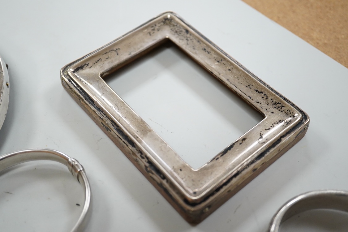 A small group of silver items including a William IV vinaigrette, William Simpson, Birmingham, 1835, 30mm, a later stamp case, two mounted photograph frames, two hinged bangles, together with a group of sterling or white